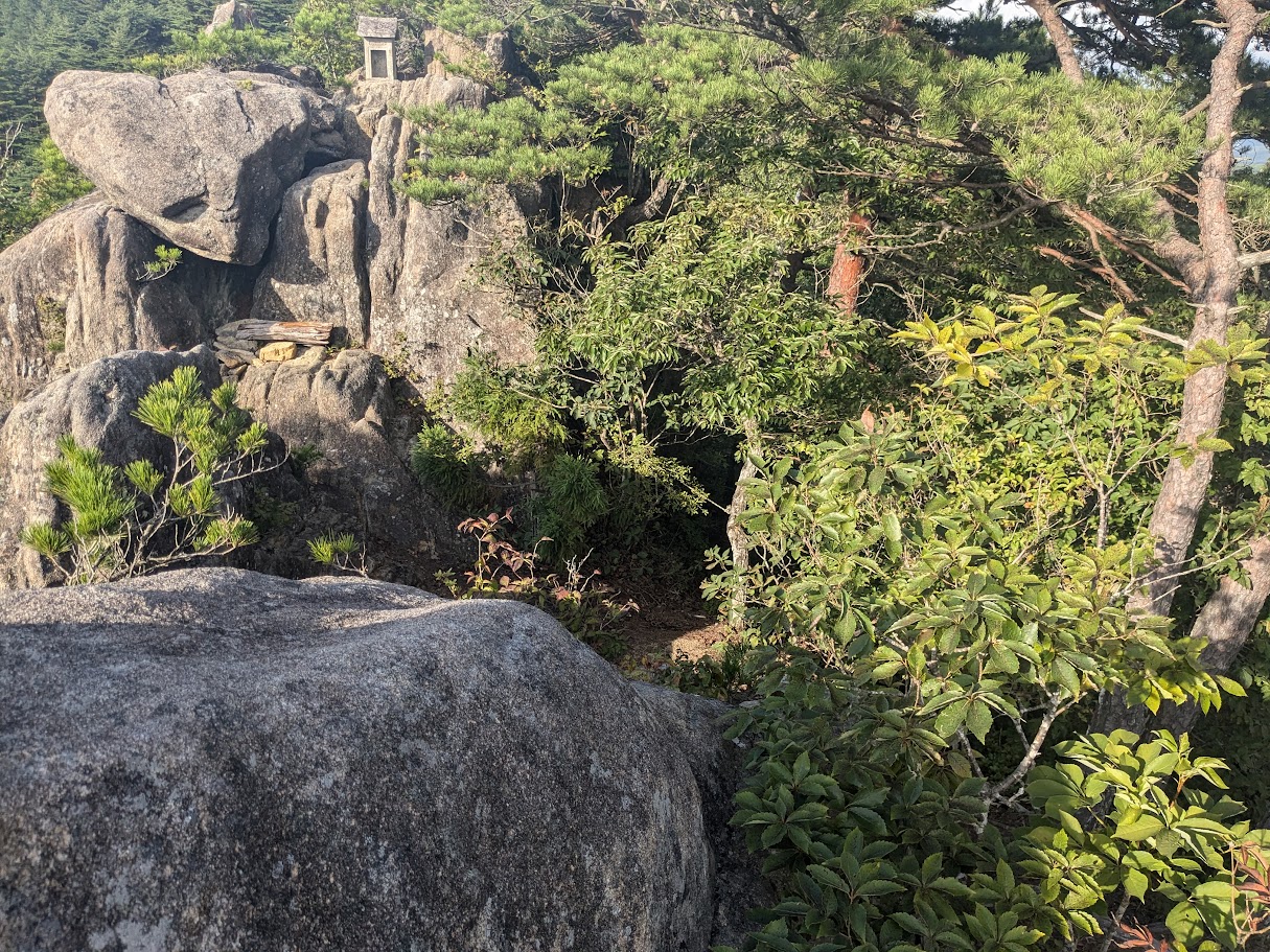霊峰の岩稜と松、遠くに広がる山並み